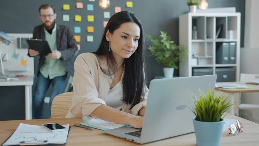 HR administrator working at a laptop in a modern office