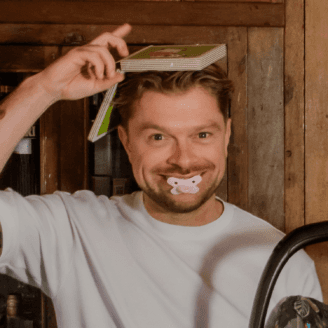 A person smiling and holding a toothbrush.