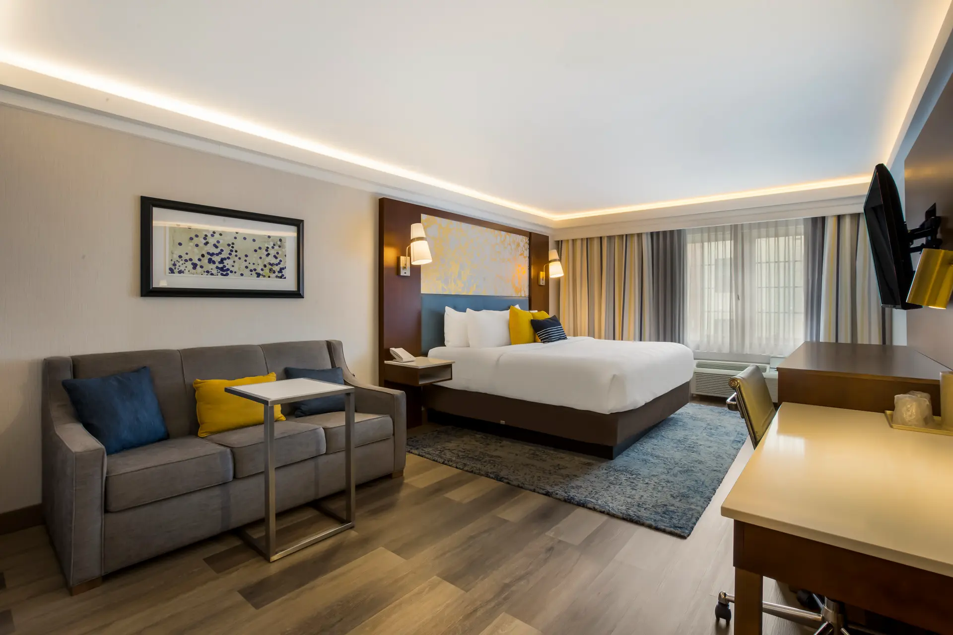 Hotel room with two beds, blue headboards, and gold marbled wallpaper.