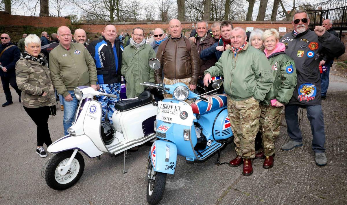 A group of people at a scooter meet