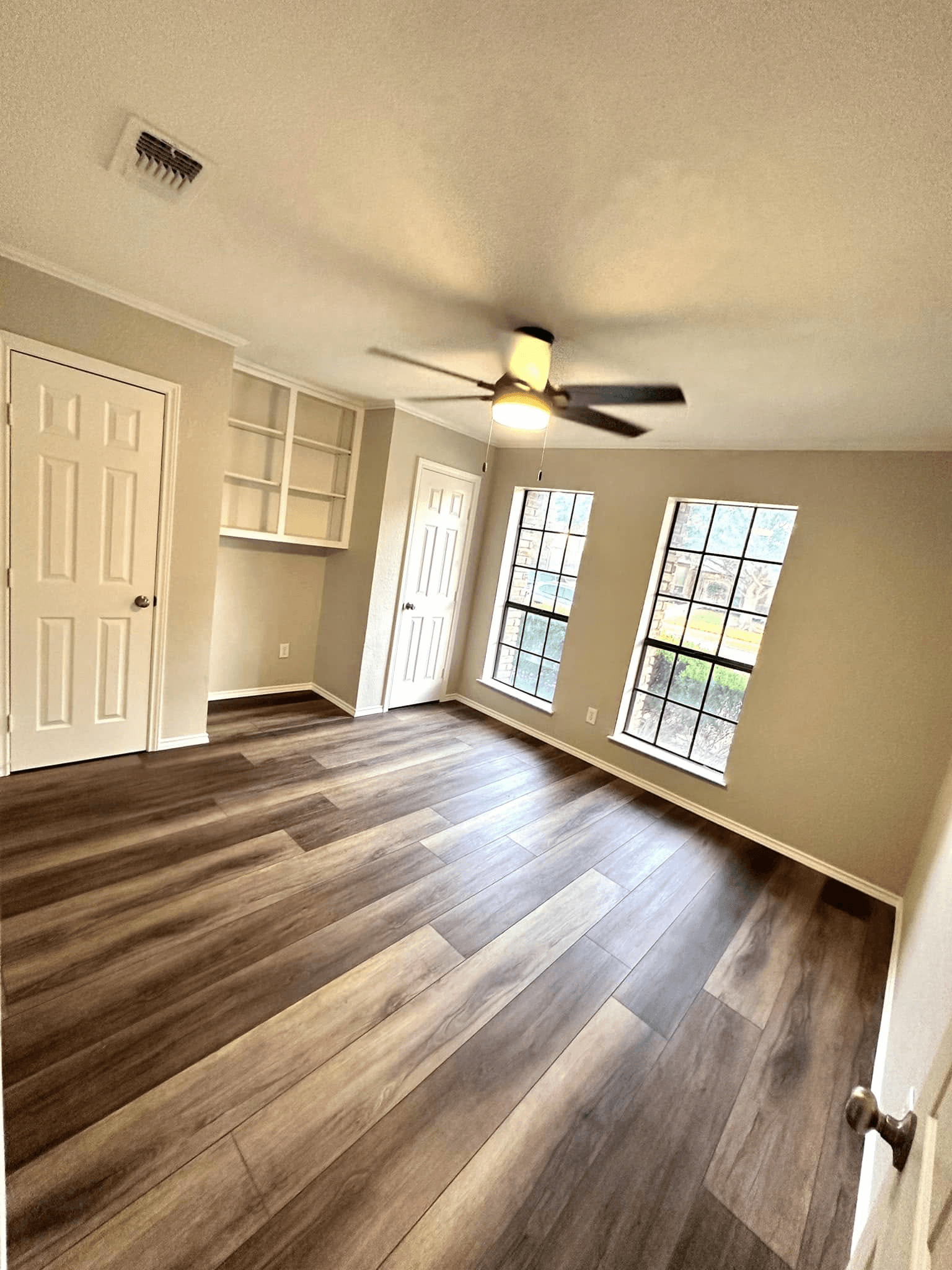 Finished room addition in a Dallas home featuring wood flooring, built-in storage, natural light, and expanded flexible living space.