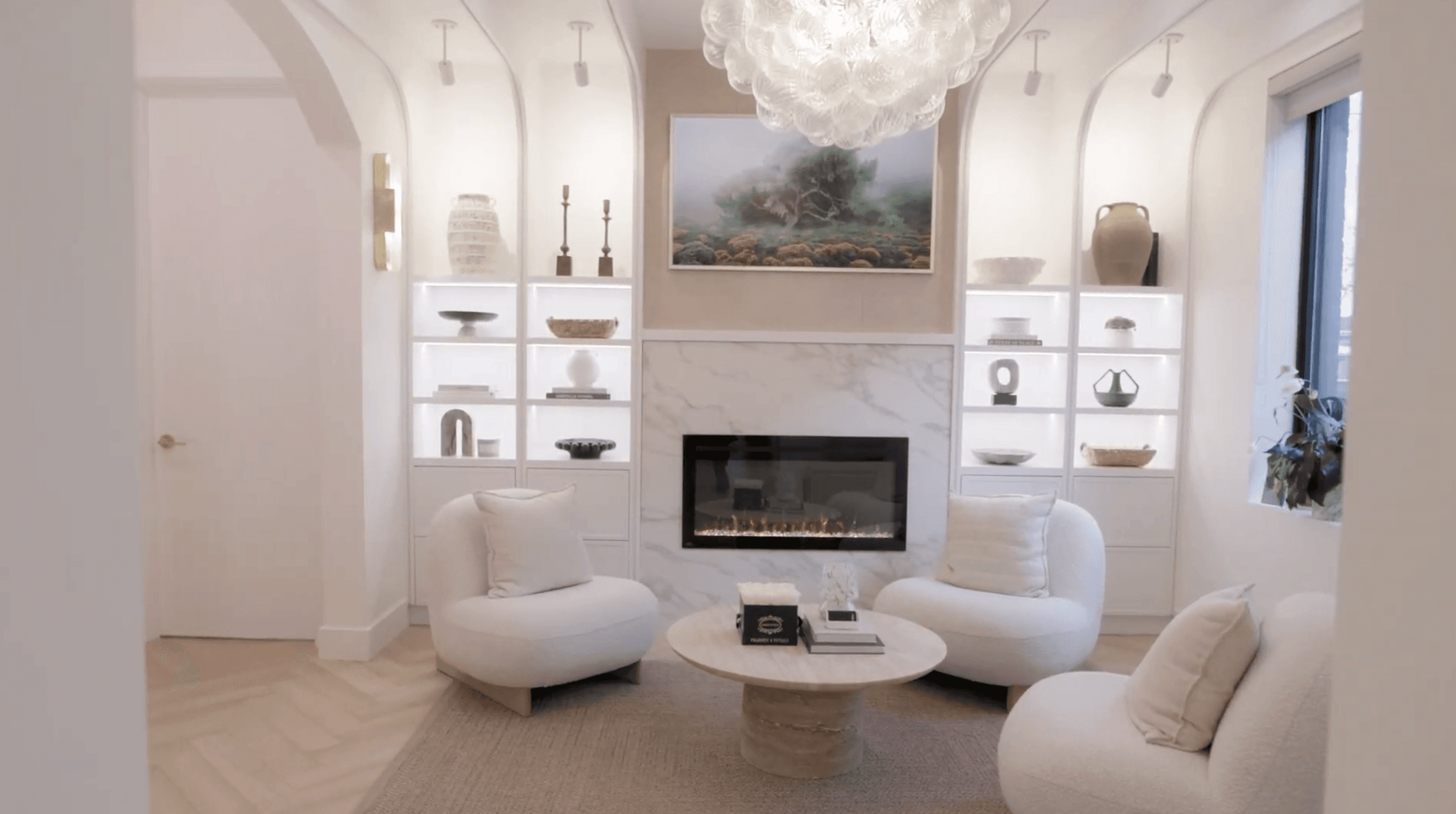 SkinAlchemy lounge with white chairs and a marble fireplace