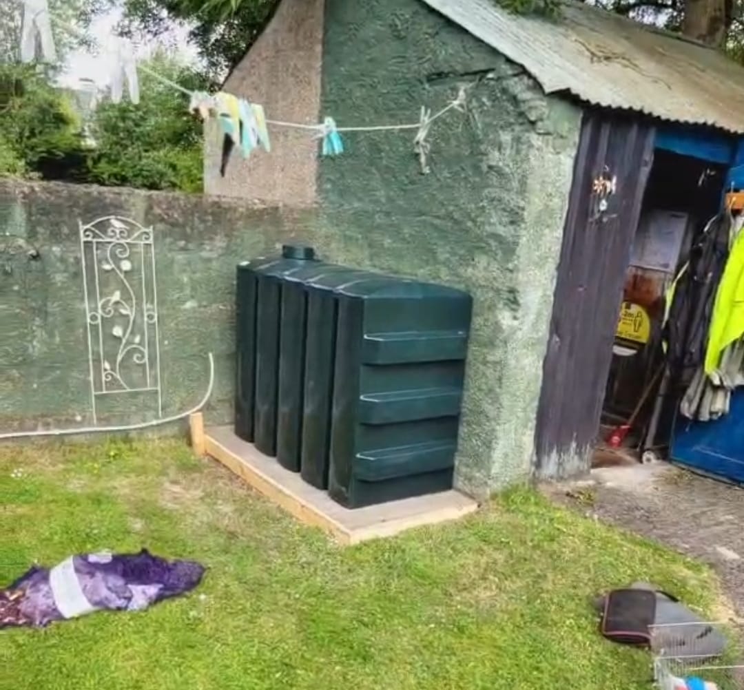 a large metal barrel sitting on top of a lush green field