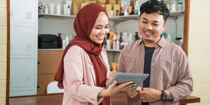 F&B staff looking at a tablet while talking to each other