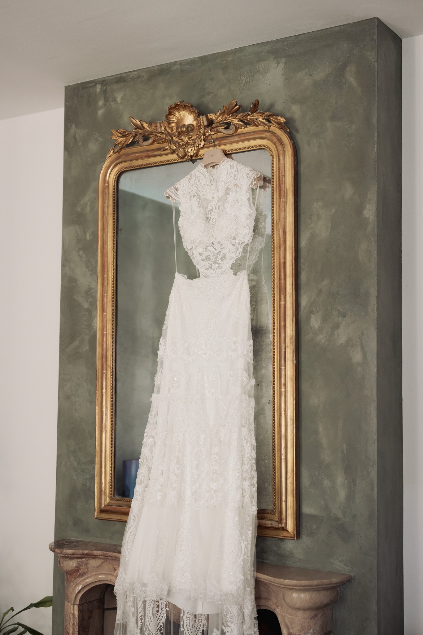 Abito da sposa in pizzo bianco appoggiato su specchio antico con cornice dorata alla Rocca di Soragna