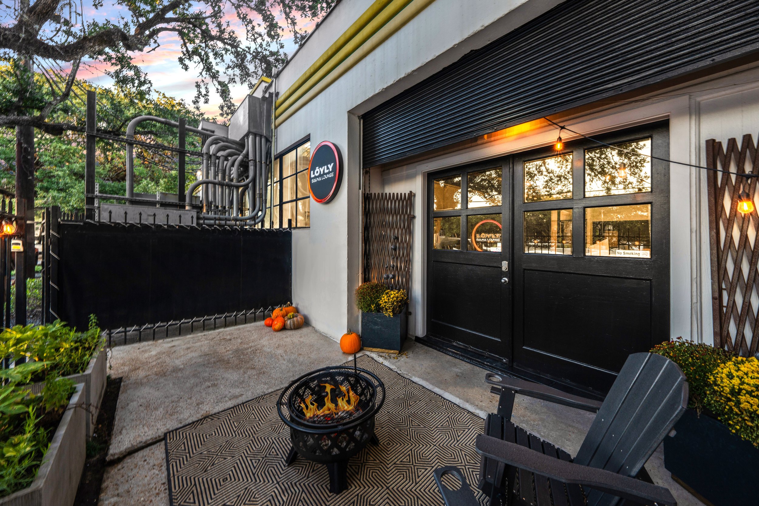 A serene spa setting with two lounge chairs beside a warm, reflective pool and soft, natural lighting.