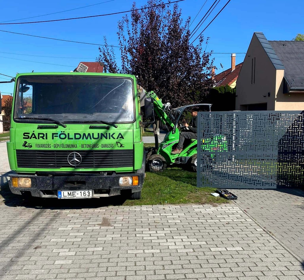 Földmunka gép sittet pakol egy platós kamionra ami sittet szállít