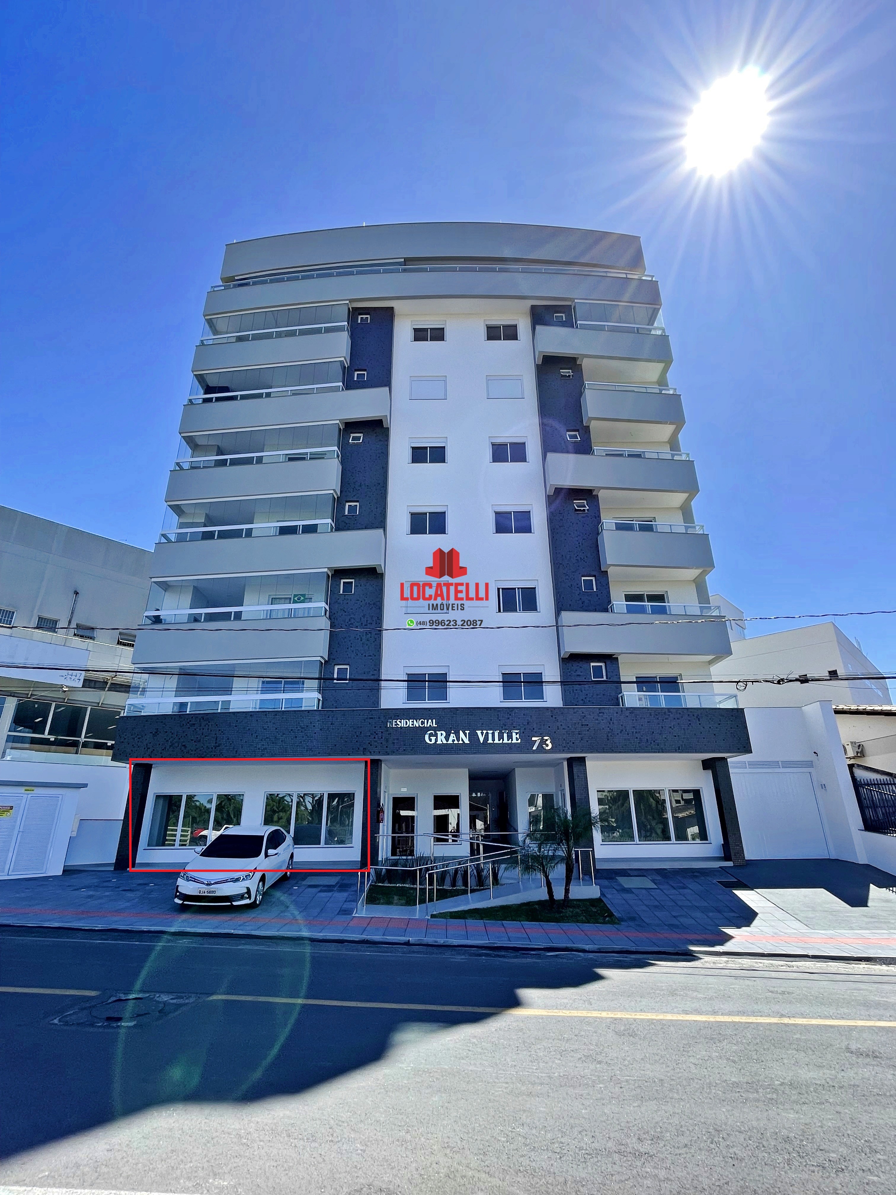 A modern brick house with a two-car garage, well-manicured lawn, and clear blue sky in the background.