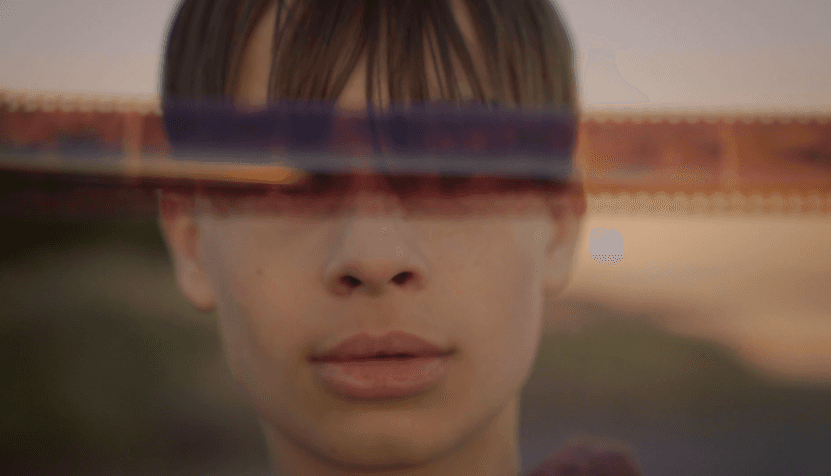 View of the French countryside through a stone villa’s open living room, with sofas and trees framing the scene