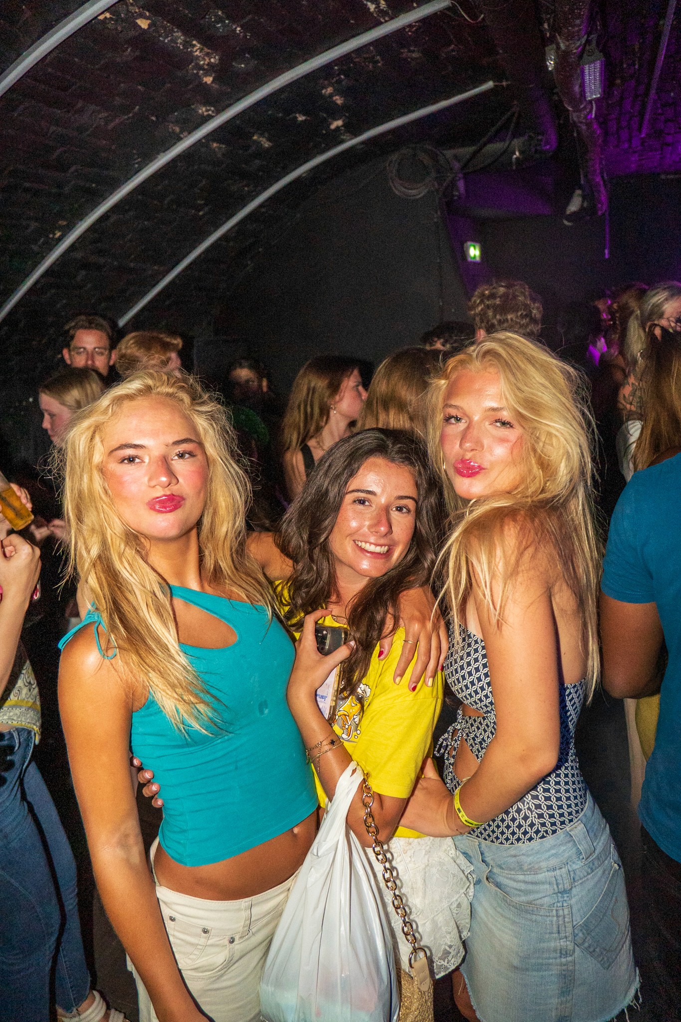 Friends posing and smiling together on a crowded dance floor during a pub crawl in Nice capturing spontaneous nightlife moments and social energy in the French Riviera