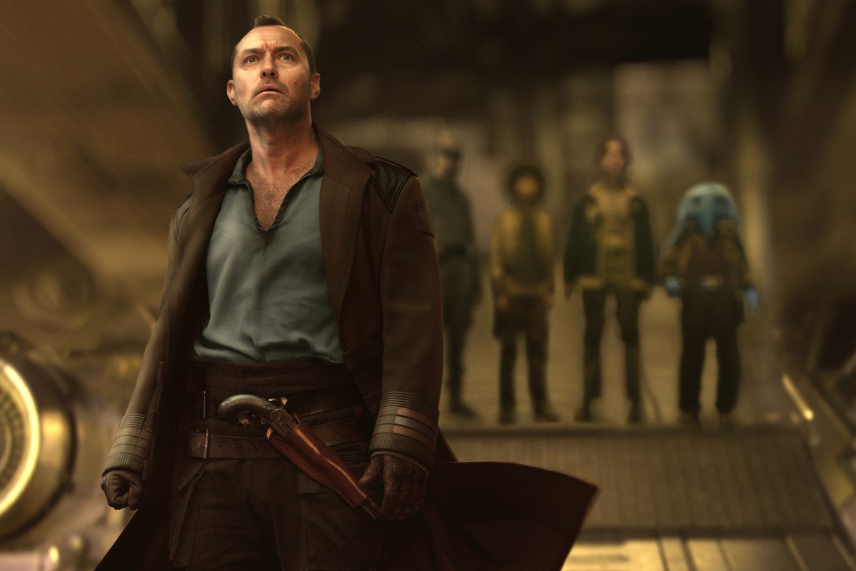 A determined man in rugged attire stands at the forefront, gripping a holstered weapon. Behind him, four blurred, diverse figures stand in a dim, industrial sci-fi setting.