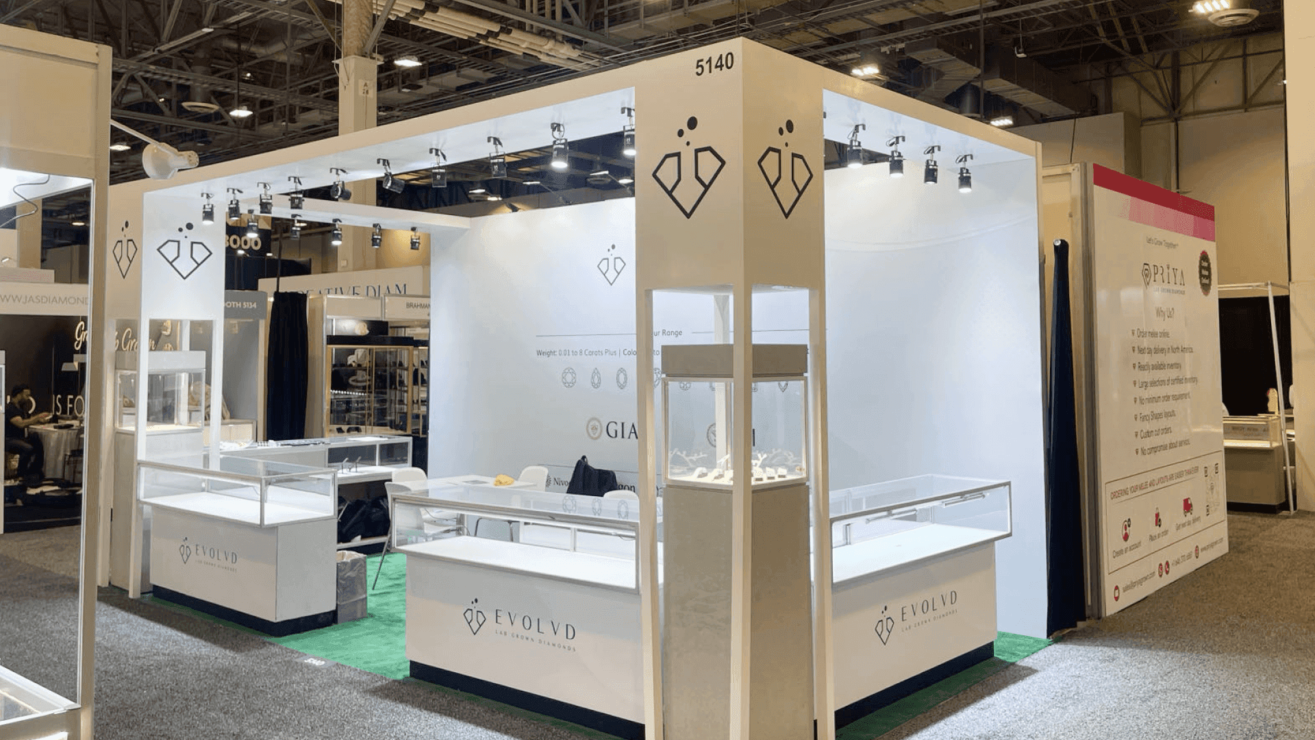 Evolvd JCK Las Vegas 2023 10x20 jewelry showcase booth with corner display tower, glass jewelry showcases, branded fascia, and buyer meeting area
