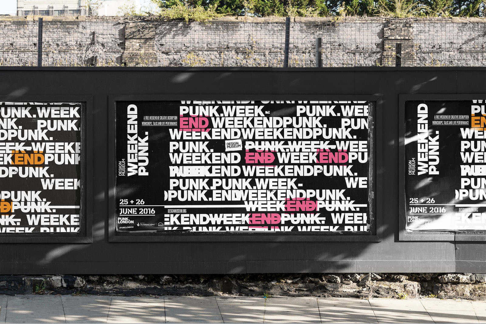 A colorful mural with abstract shapes and patterns on a black wall, set in an outdoor environment.