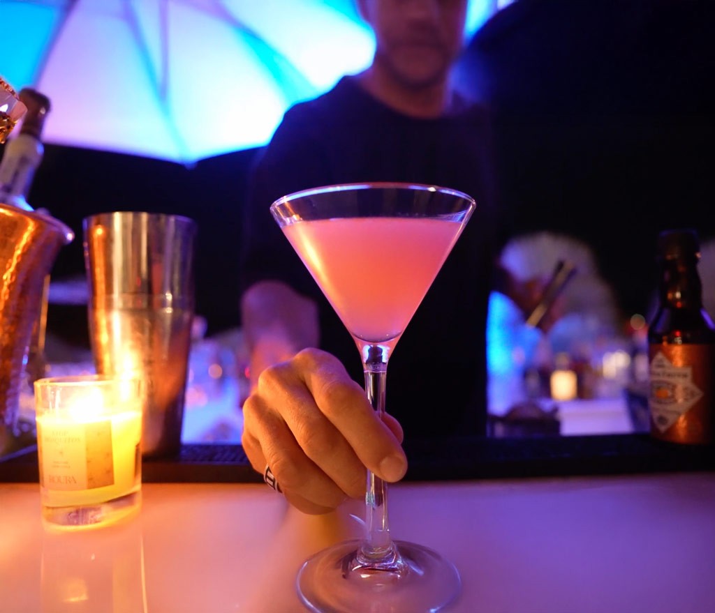 Cocktail being served at a night bar with martini glass, candlelight and event