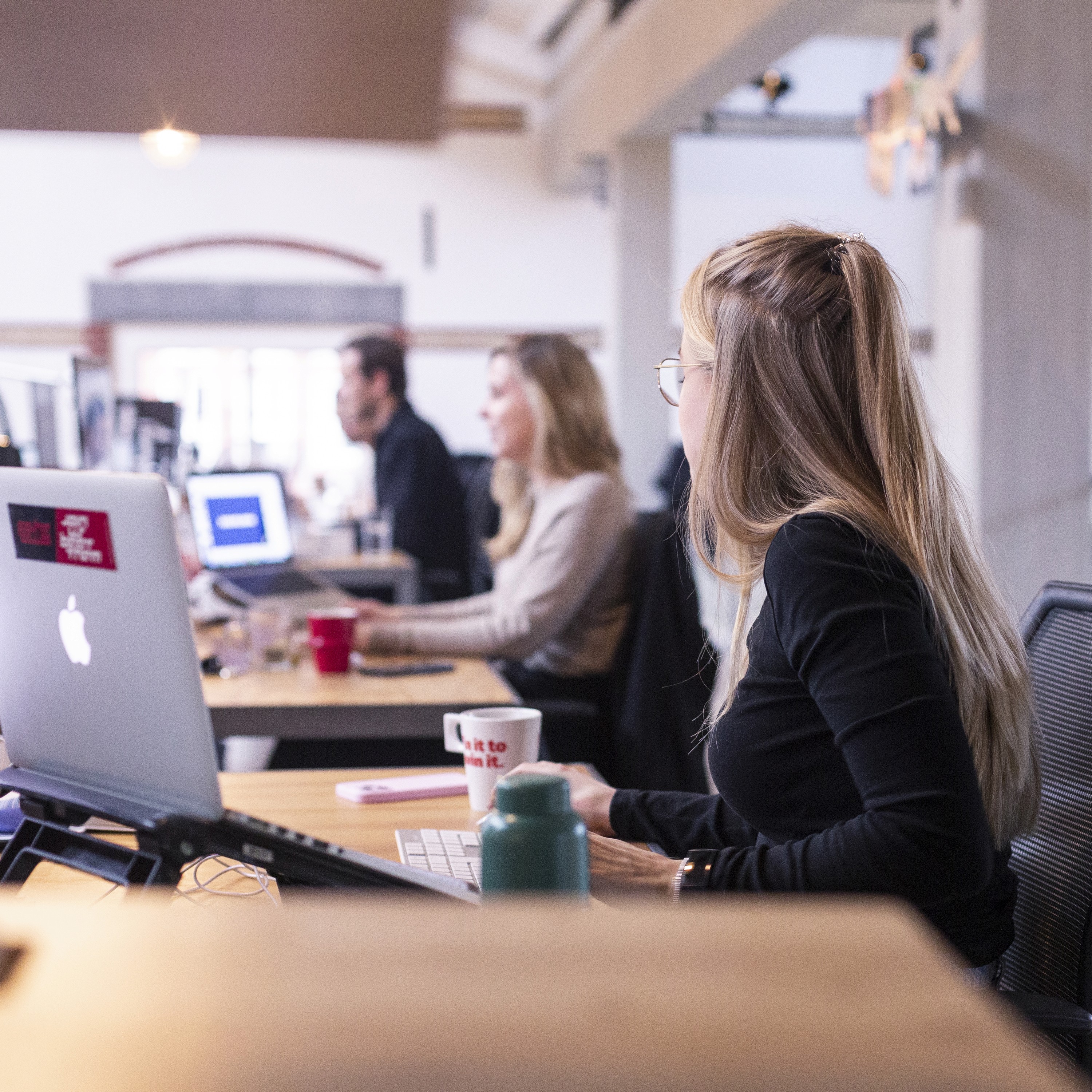 a row of people hard at work at their desks