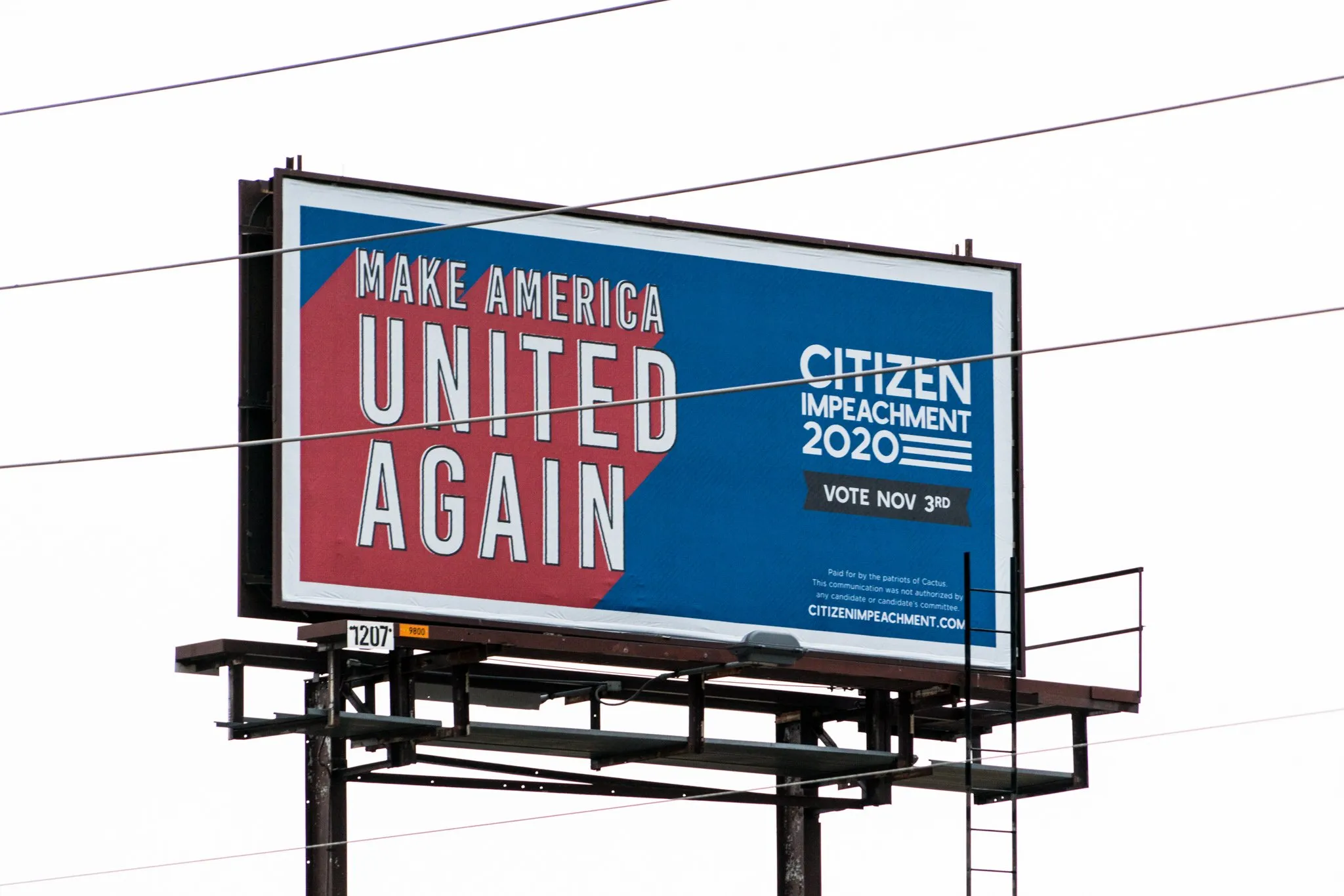 a man walking down a street past a large poster