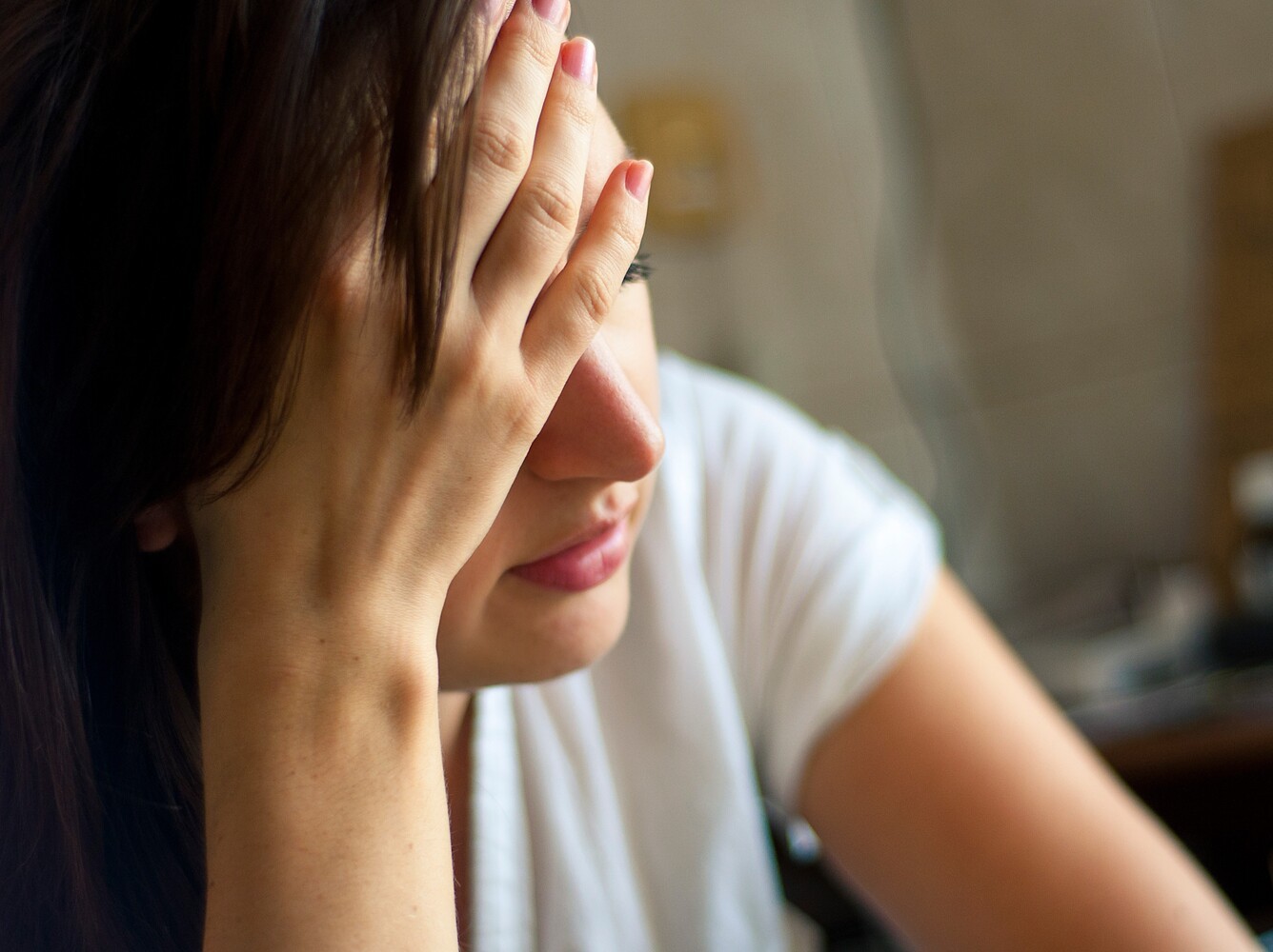 fatigued woman holding her head after learning how to lose weight with pilates and overdoing it without rest