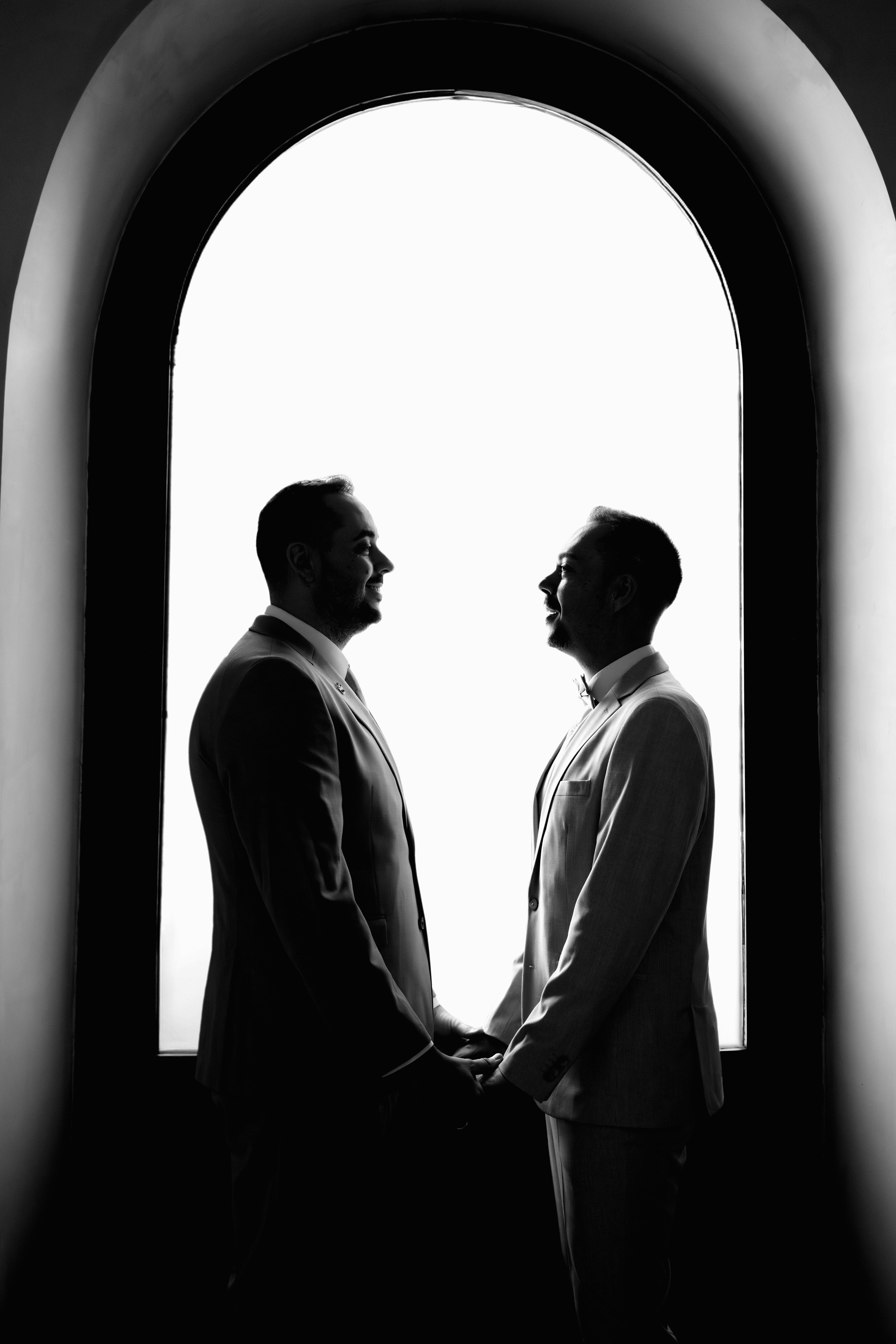 Sesión de boda. Pareja en una ventana en blanco y negro mirandose