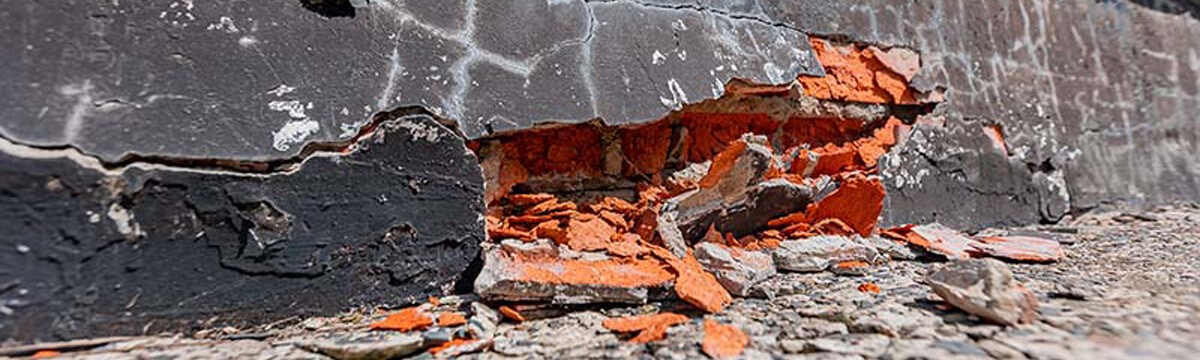 A cracked foundation exposing concrete ruble that depicts construction defect.