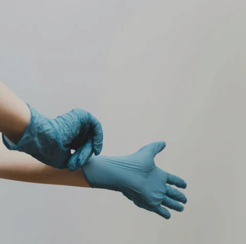 person in blue gloves and blue denim jeans