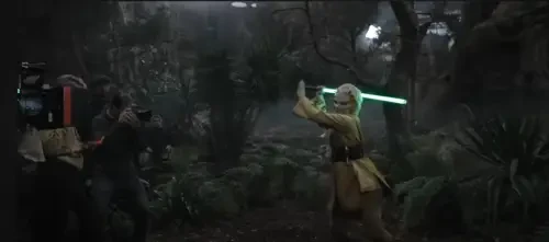 Jecki Holding her lightsaber high in front of a camera