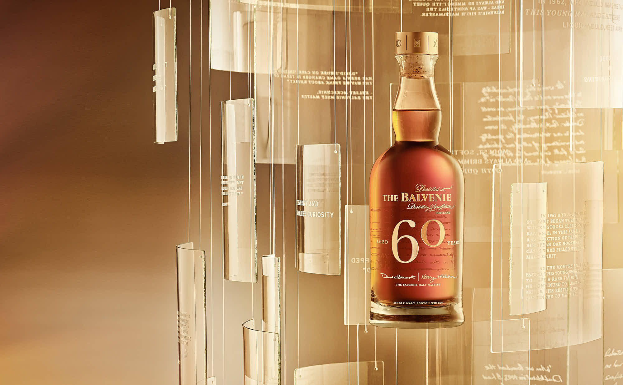 A bottle of whiskey is suspended among illuminated, translucent panels, creating a warm ambiance.
