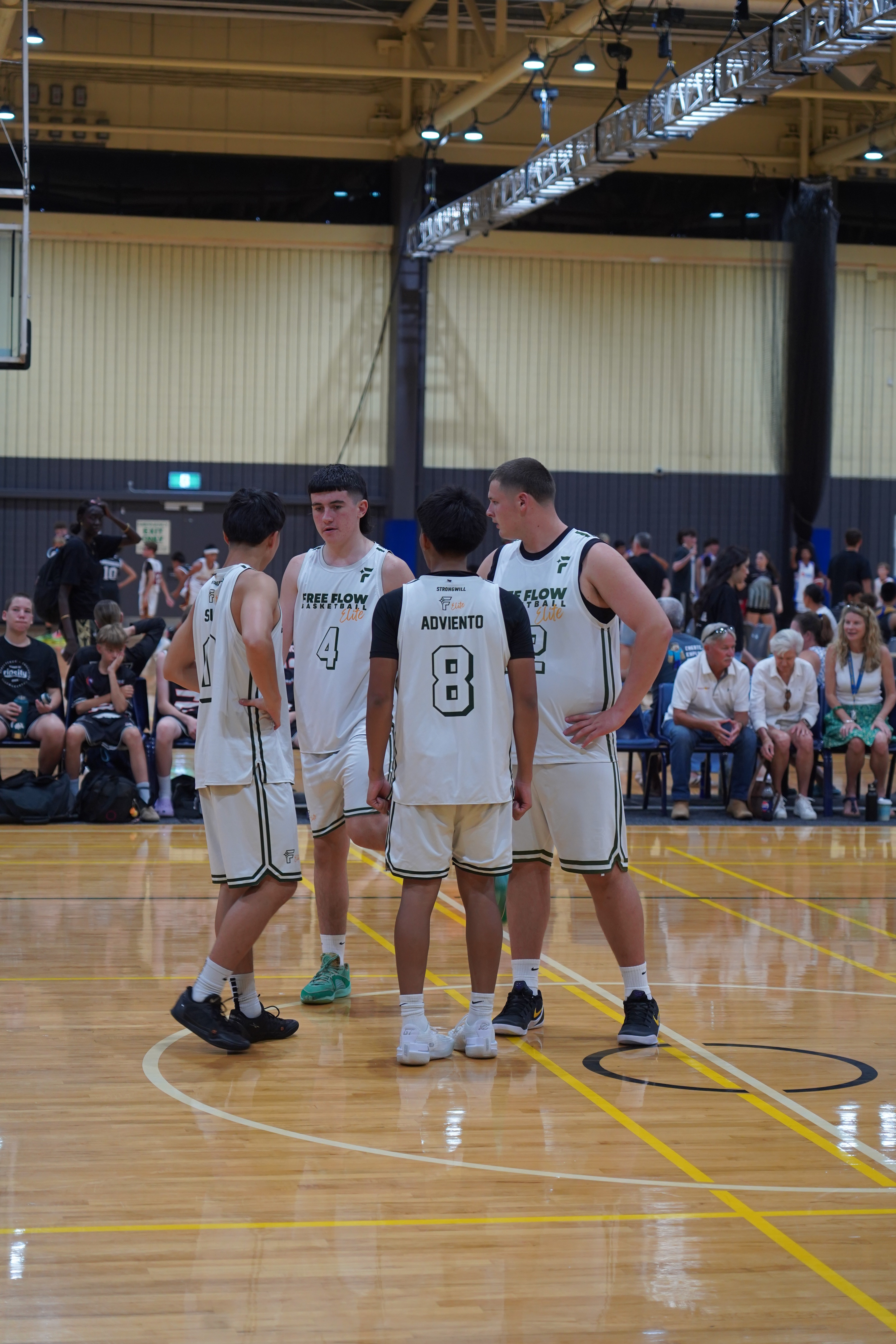 Free Flow Basketball players engaaged in a on court team huddle