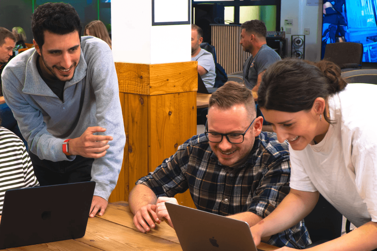 People looking at a laptop on the floor.