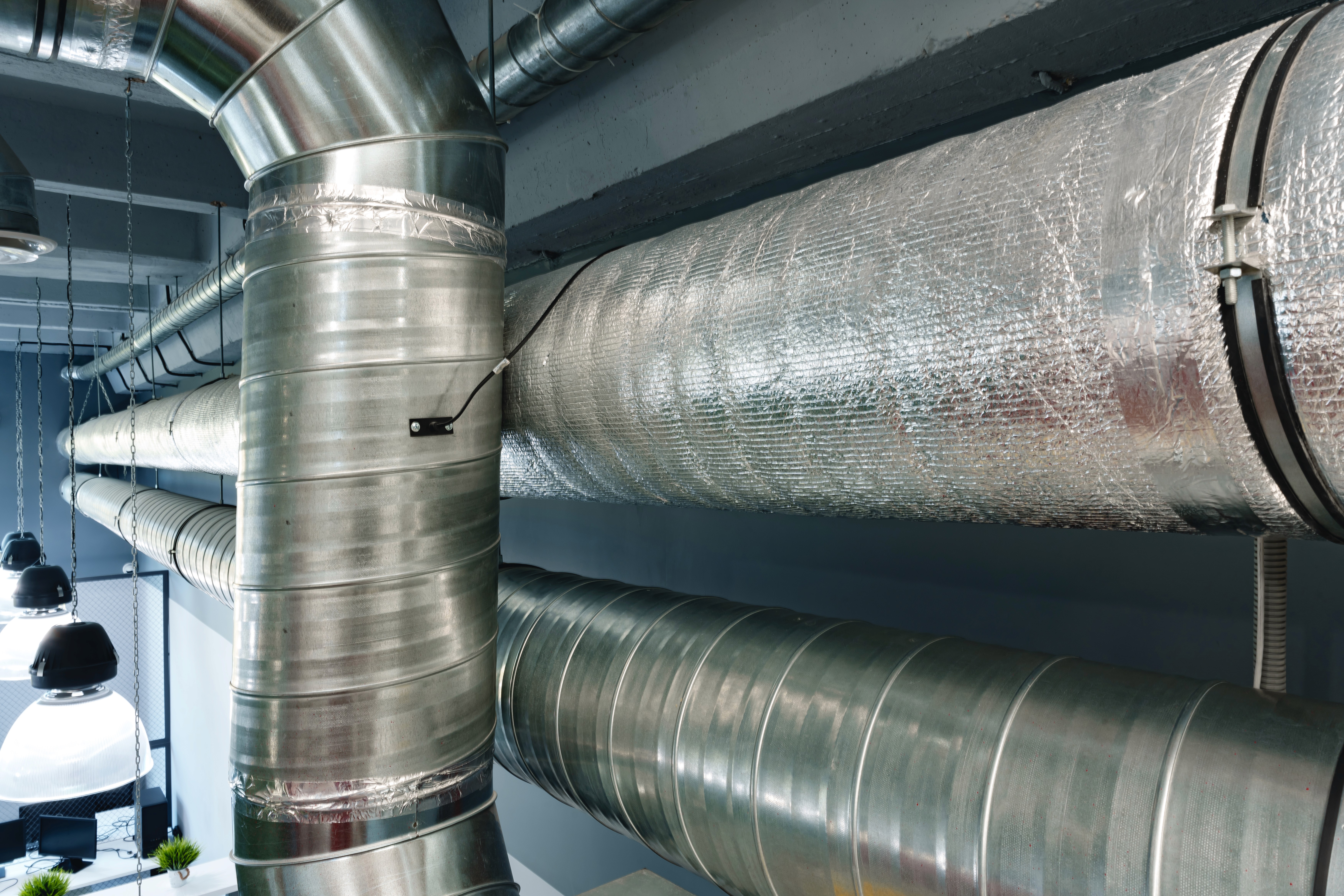 Reflective bubble foil insulation and fiberglass compared on commercial HVAC ductwork in a mechanical room