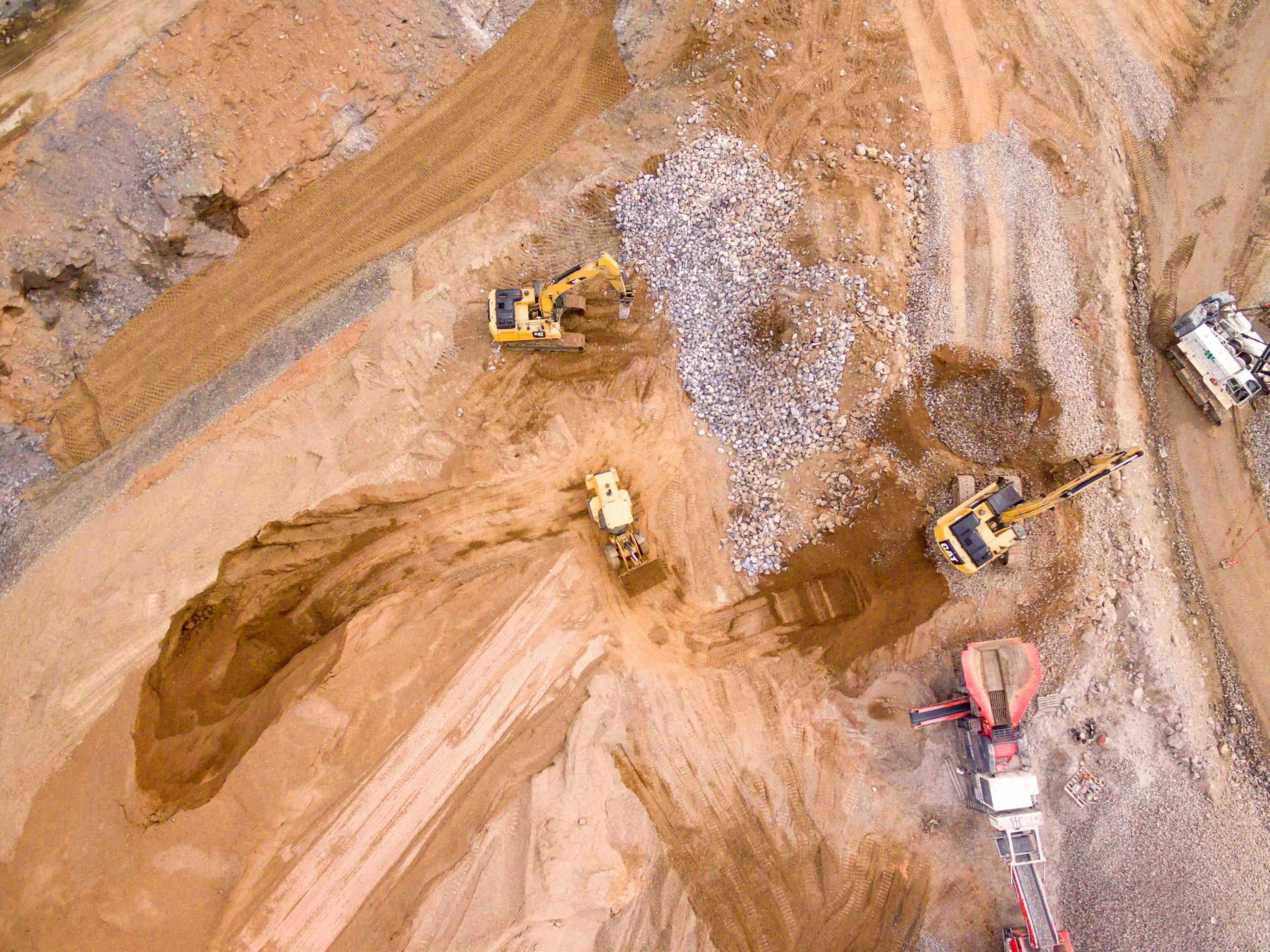 aerial photography of three heavy equipment