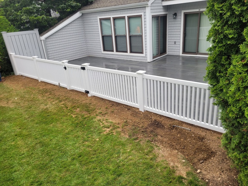 small white fencing lining a backyard deck