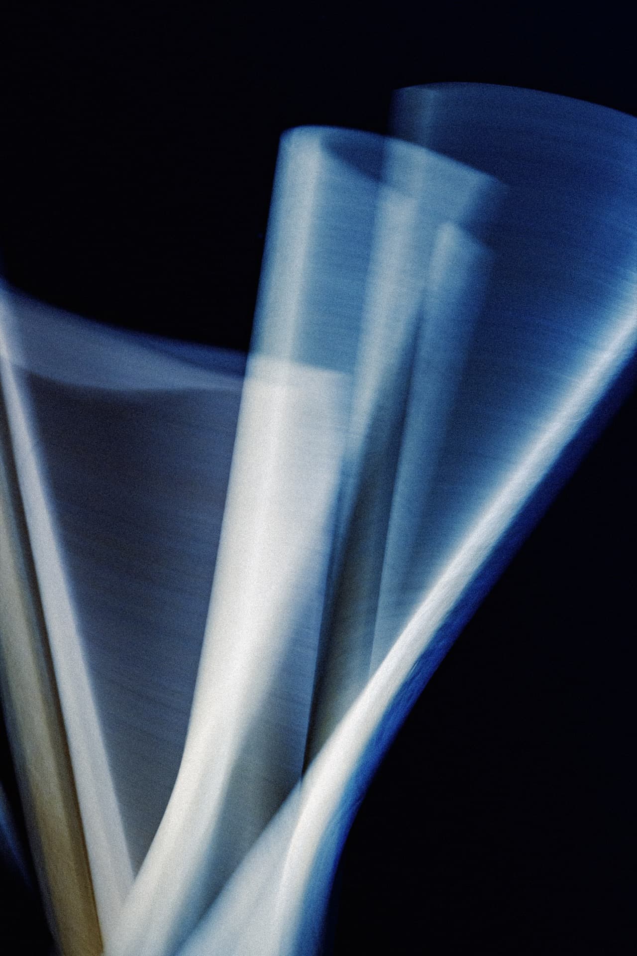 Long exposure photograph of HB pencils in motion, creating diagonal bands of light across blue-toned forms, slow shutter speed capturing movement as smooth gradient from deep blue to pale
