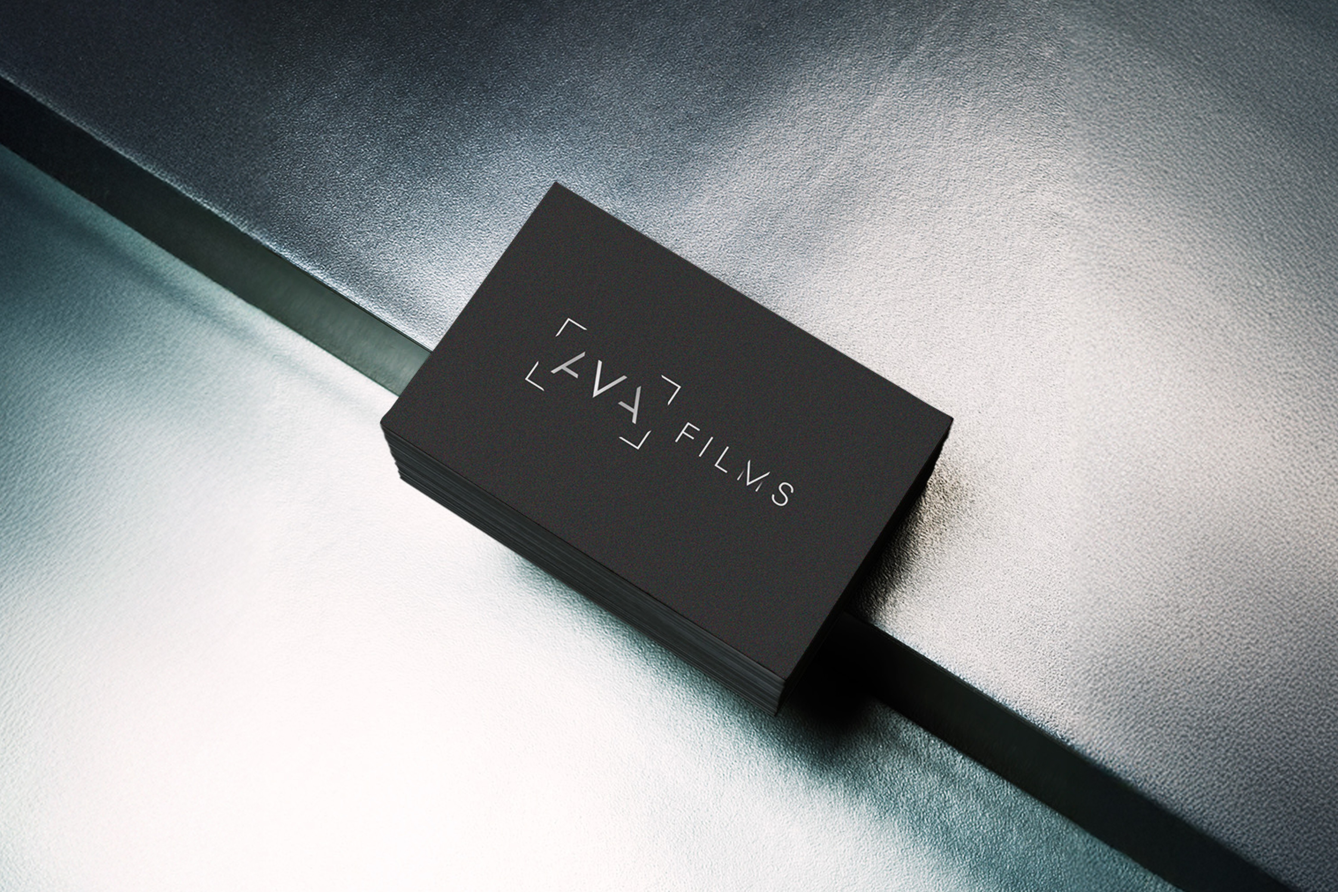 Minimalist AVA Films black business card with sleek metallic lettering, capturing the essence of luxury videography in high-end industries like real estate and yachting.