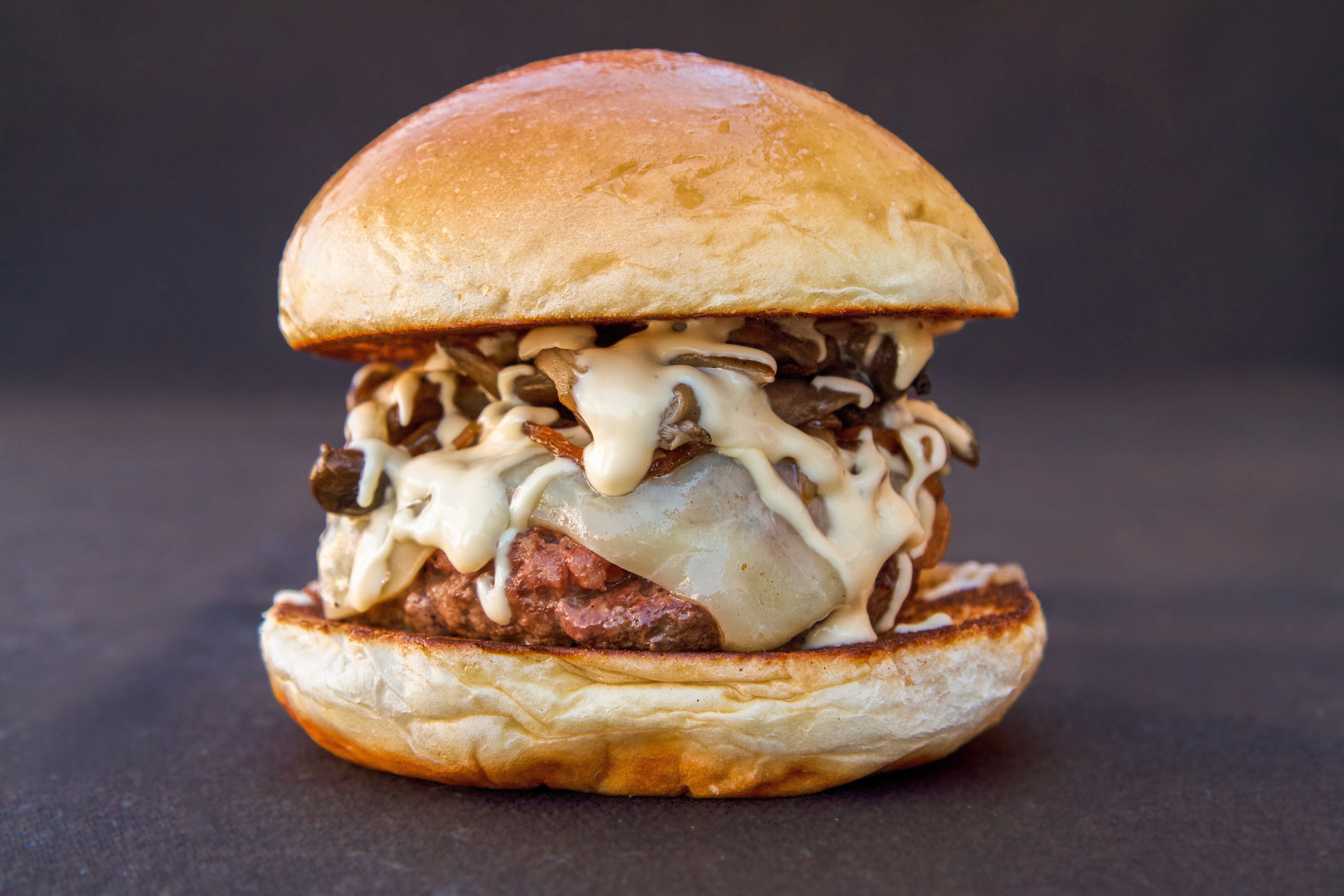 A stack of glazed, braised pork belly cubes (possibly Chinese Red Braised Pork or Japanese Kakuni), drizzled with a dark sauce and topped with shredded green onions and orange zest, served on a vintage metal plate.