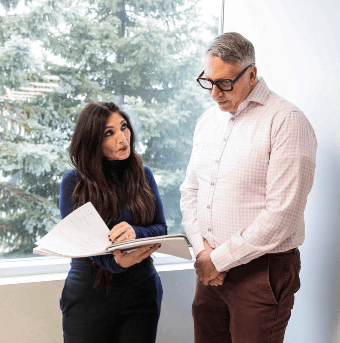 Two SteriMax team members reviewing documents together in an office by a window.
