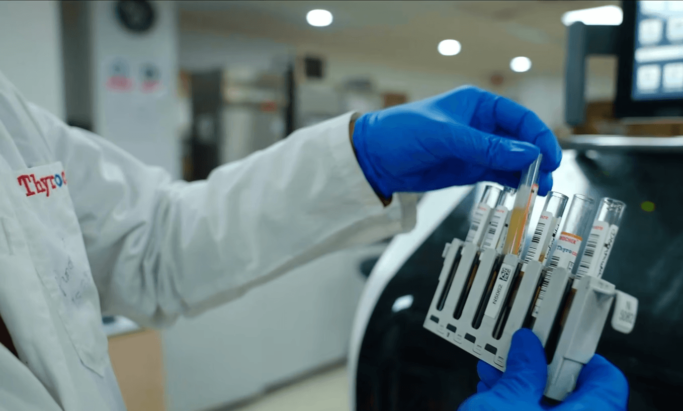 Image of a lab technician handling test tubes in a medical laboratory for a healthcare and pharma video.