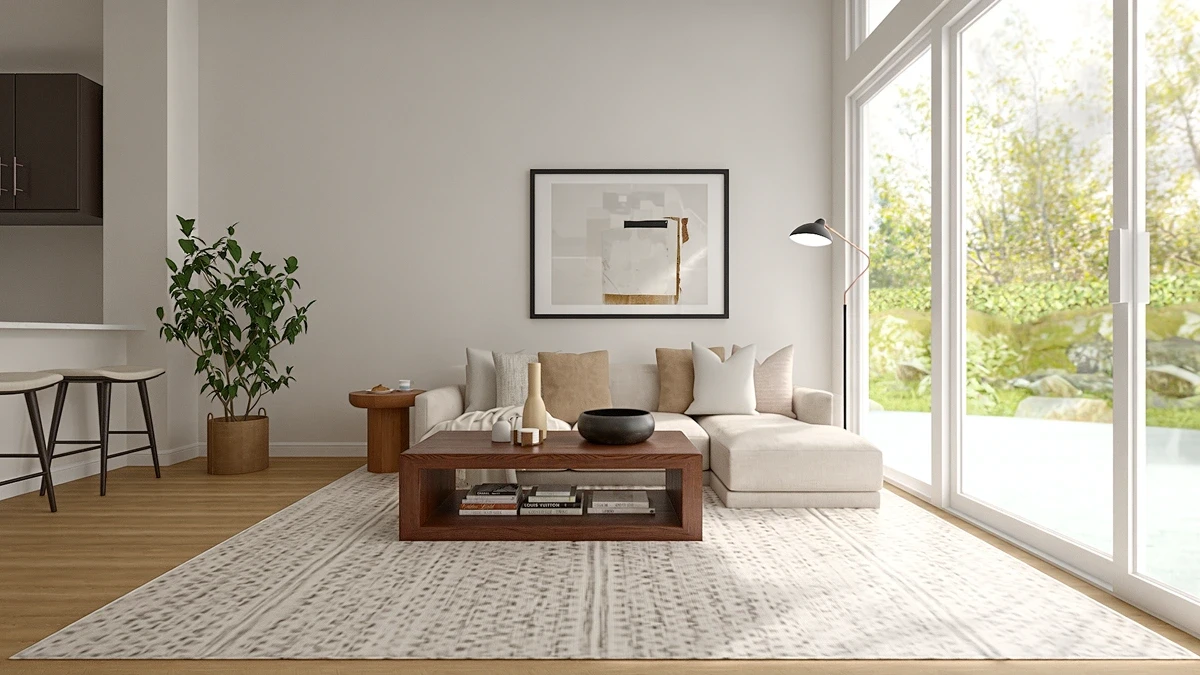 Open-concept living room with a beige sectional, wood coffee table, kitchen counter with stools, and a potted plant.