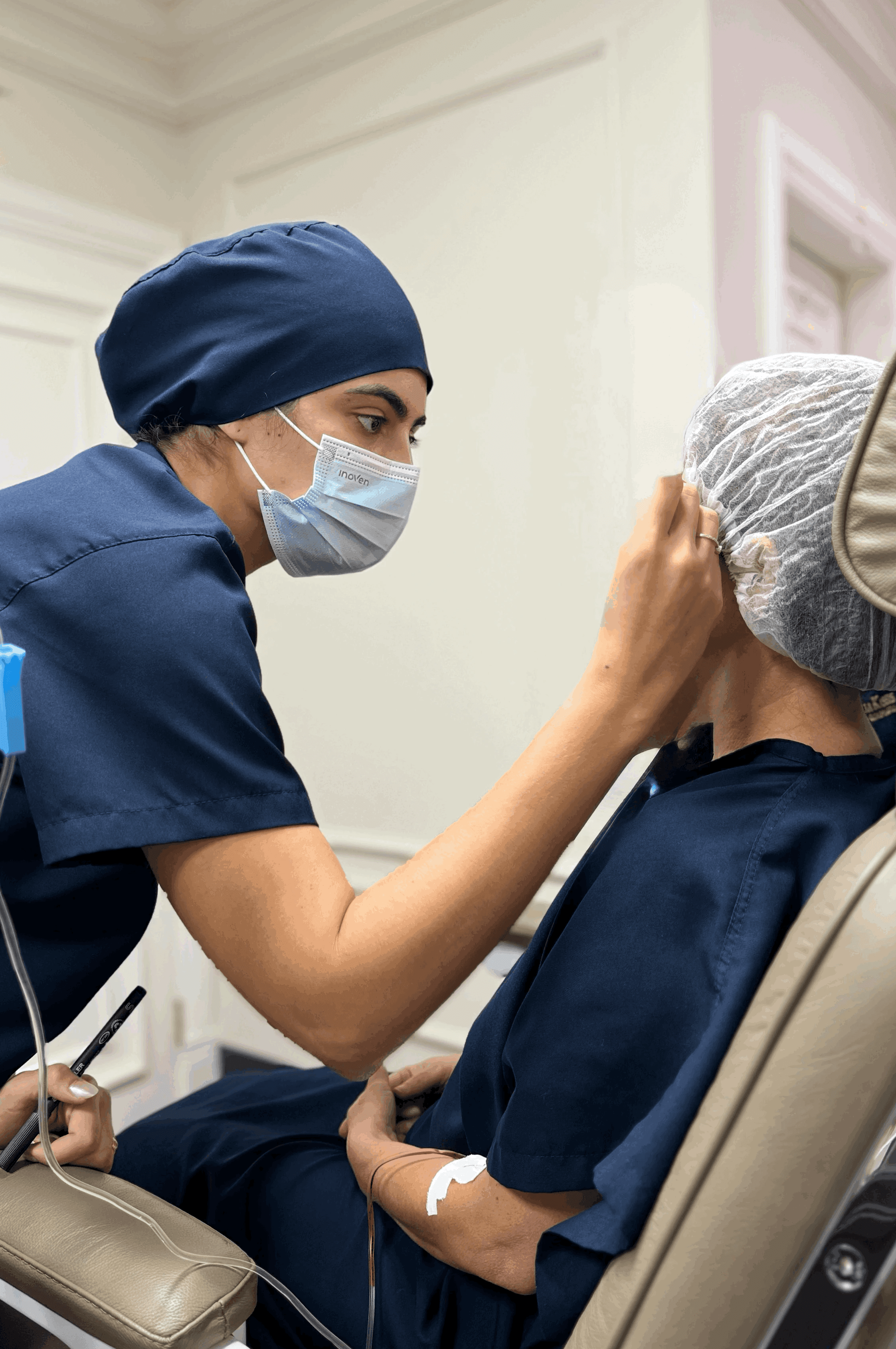 A circle of people sitting cross-legged, meditating with hands in a prayer position. Soft, warm lighting.