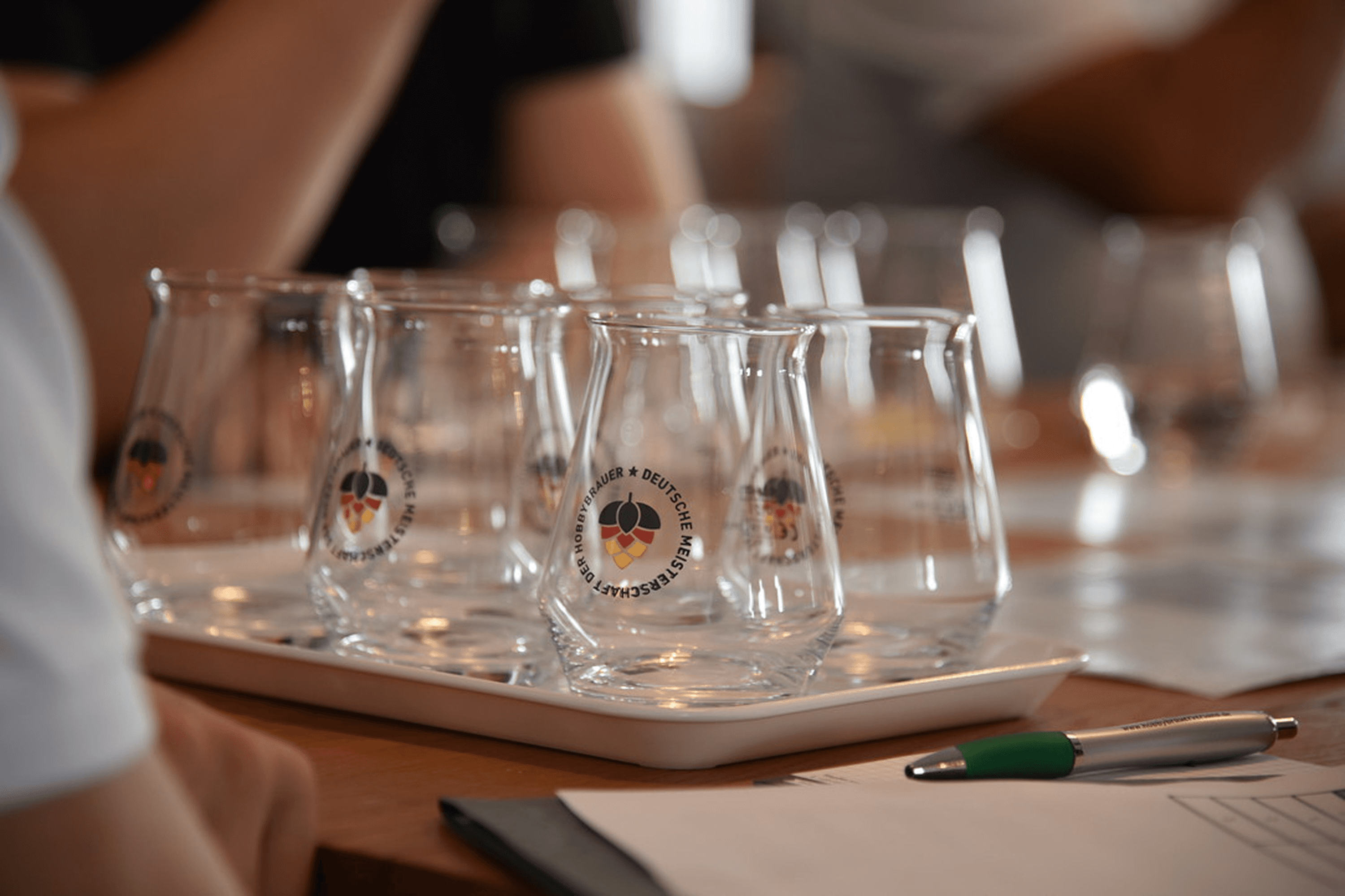 Tasting glasses on a tray with a pen and paper