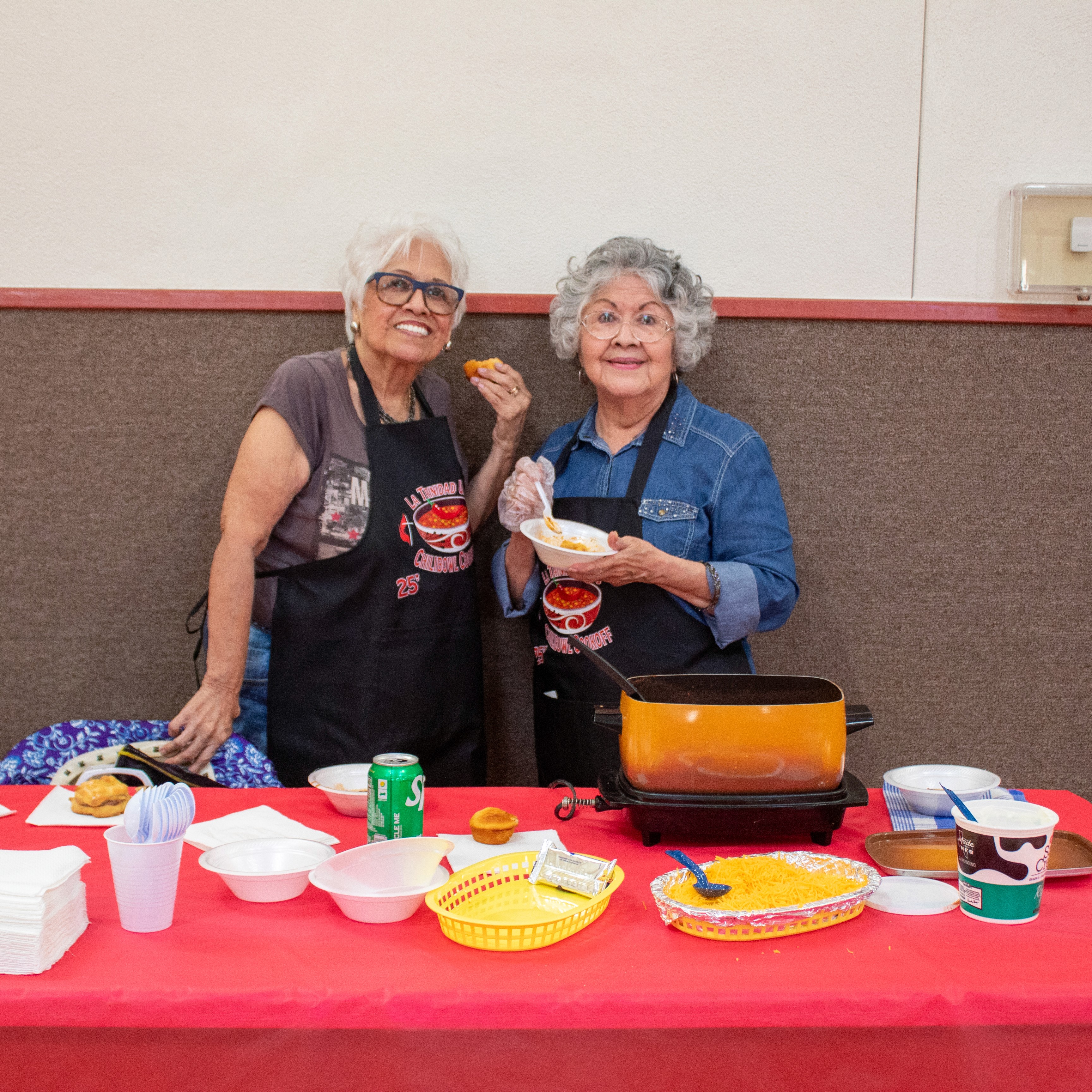 two ladies holding chili cookoff items