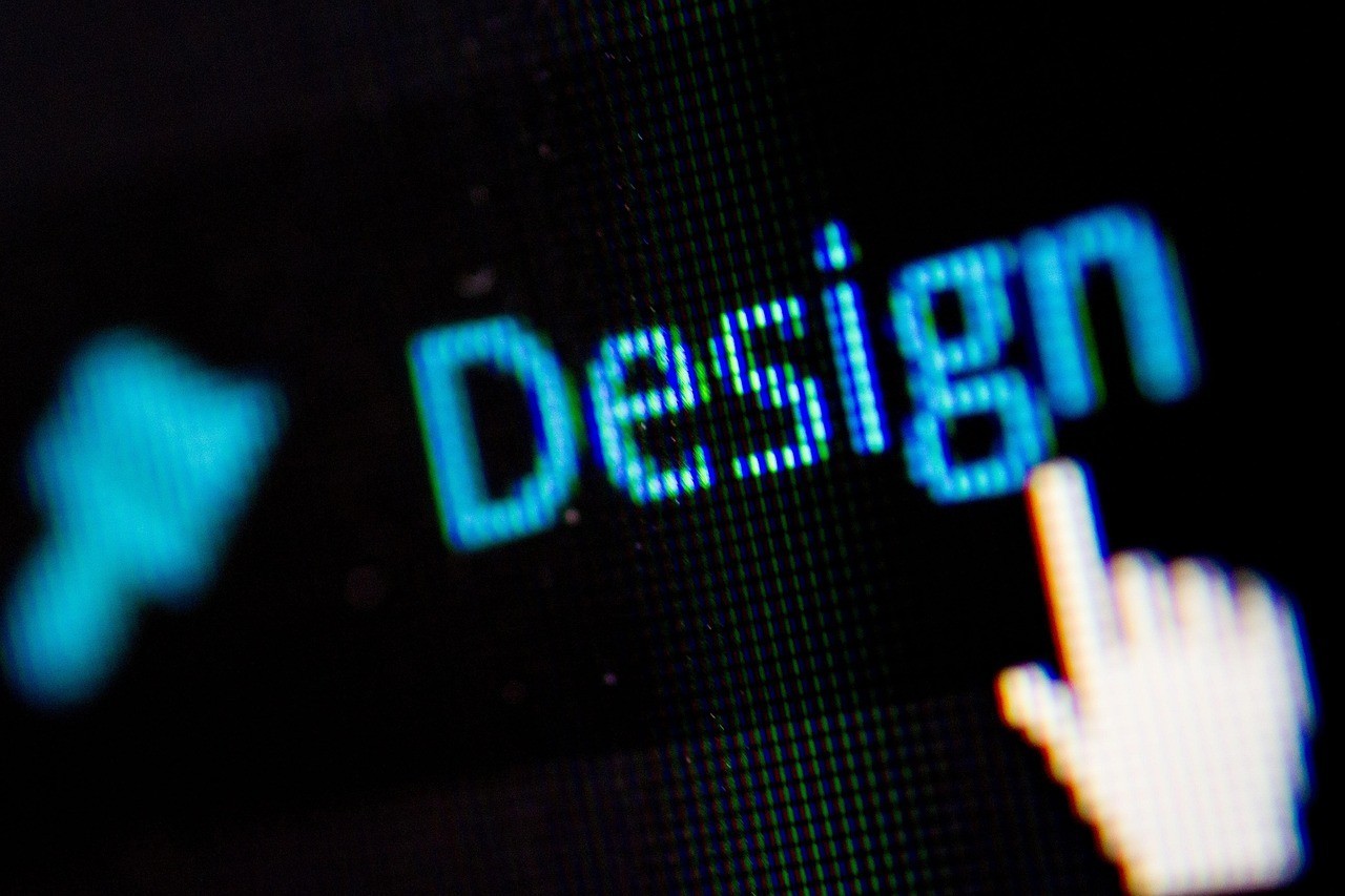 Close-up of the word “Design” on a digital screen with a finger touching the interface, representing digital product design.
