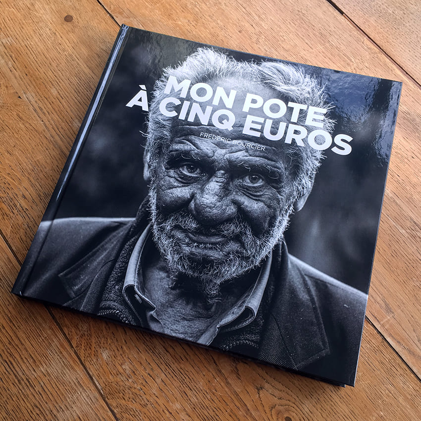 Livre photo Mon pote à cinq euros de Frédéric Bourcier, posé sur un parquet en bois.