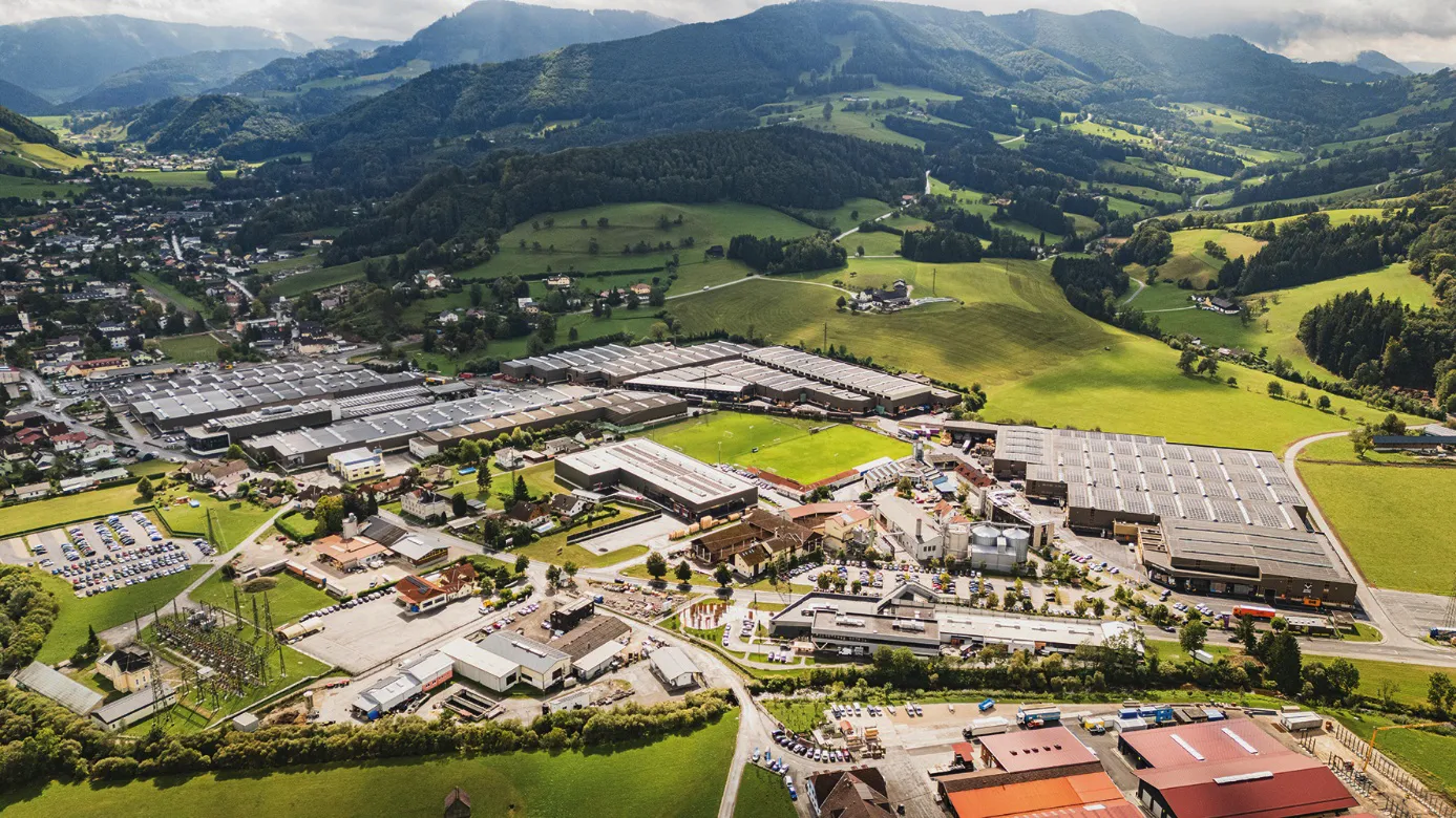 Modern commercial complex at day and a green scenery and mountains