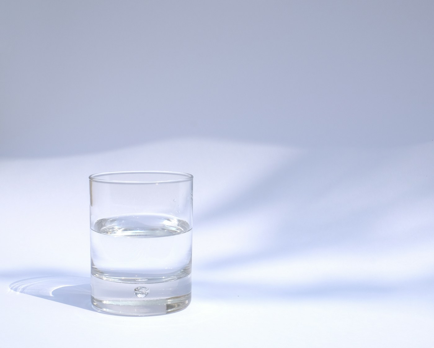 A clear glass filled with fresh water, a simple reminder to stay hydrated through the demands of newborn care