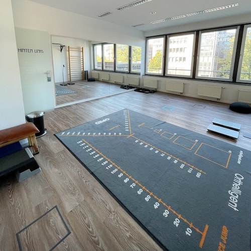 Zu sehen ist eine Spiegelfront. Davor liegt im Raum die Testmatte mit den aufgemalten Markierungen. 