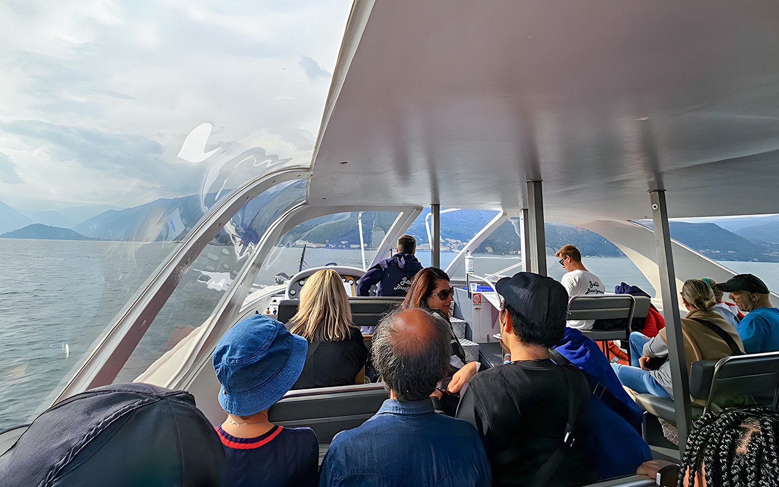 Passengers enjoying a scenic view on a boat trip in Lugano, Switzerland.