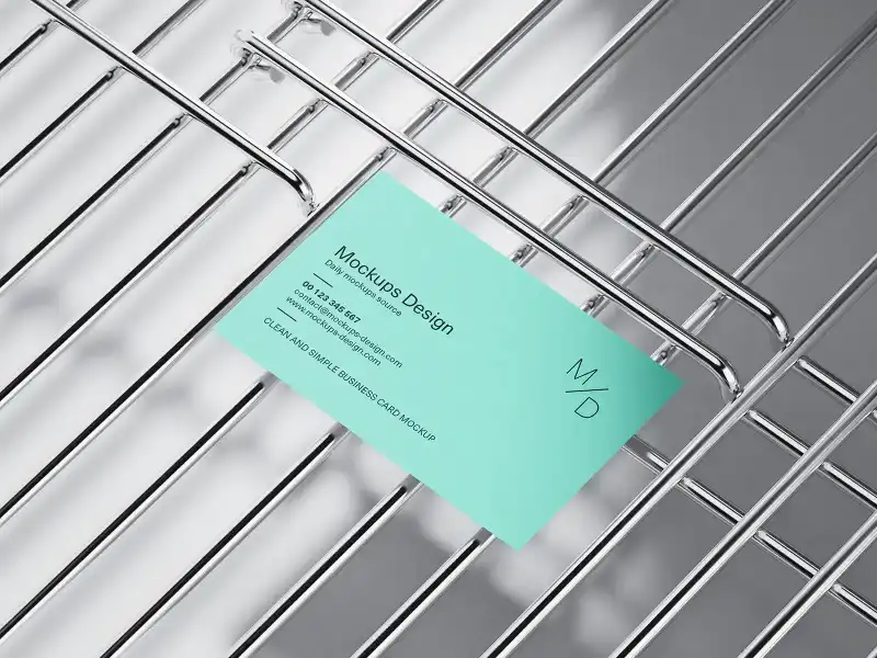 Minimal business card mockup in teal, placed on a chrome wire grid. The sleek metallic background adds a modern, industrial contrast, ideal for clean, professional branding presentations.