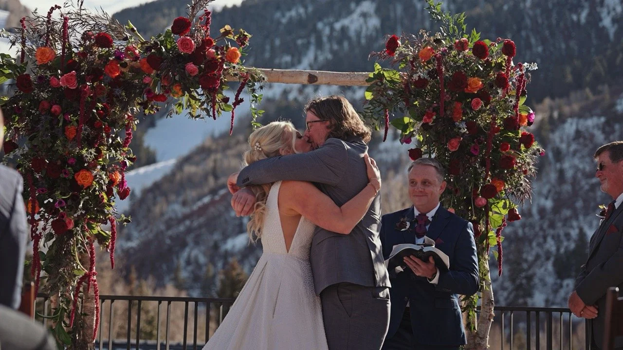 Aspen wedding videography on Aspen Mountain with bride and groom skiing in wedding attire