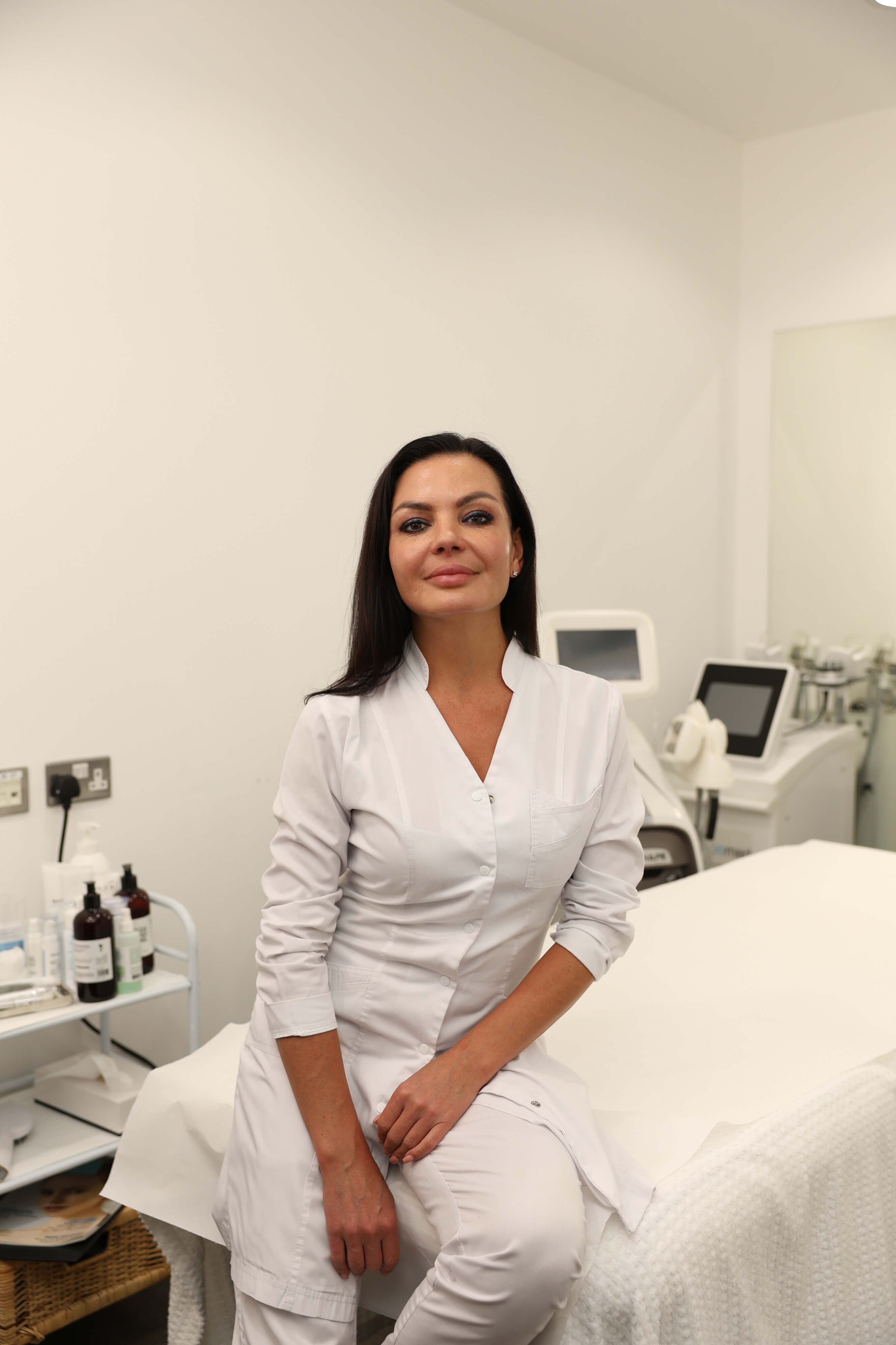 Portrait of an aesthetic practitioner inside the treatment room at SIGMA Skin Clinic.