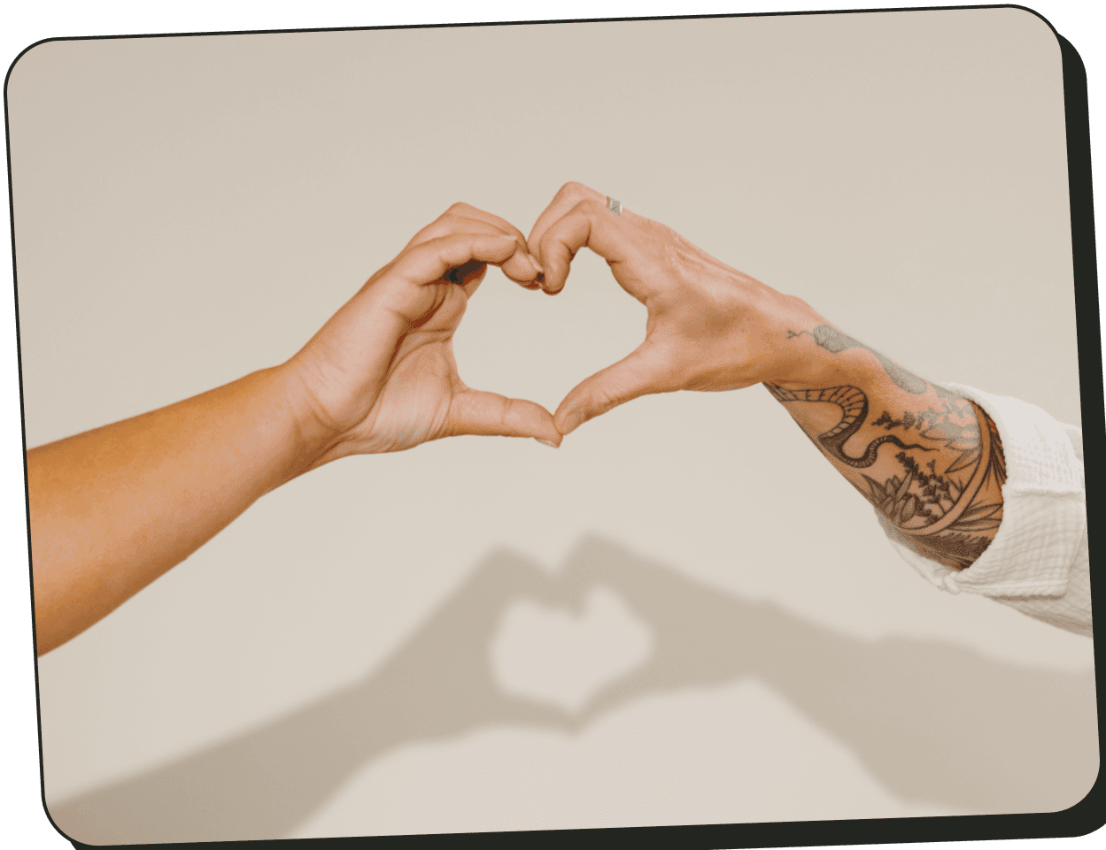 Two hands making a heart with a shadow of a heart behind them